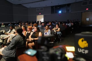 The audience at Voices Live at the University of Central Florida, a UCF-marked camera in the foreground